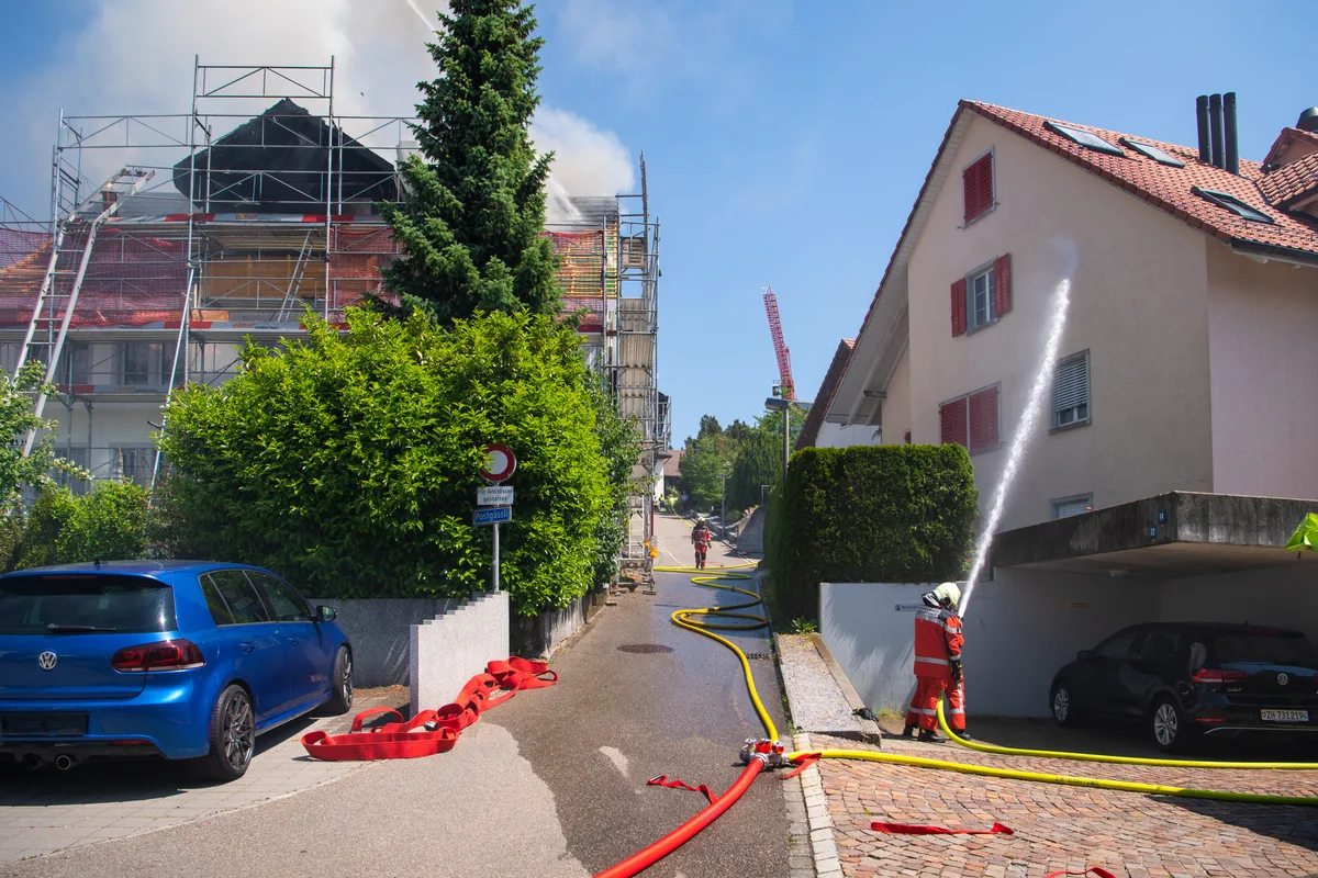 Ein Feuerwehrmann besprüht ein Haus mit Wasser.
